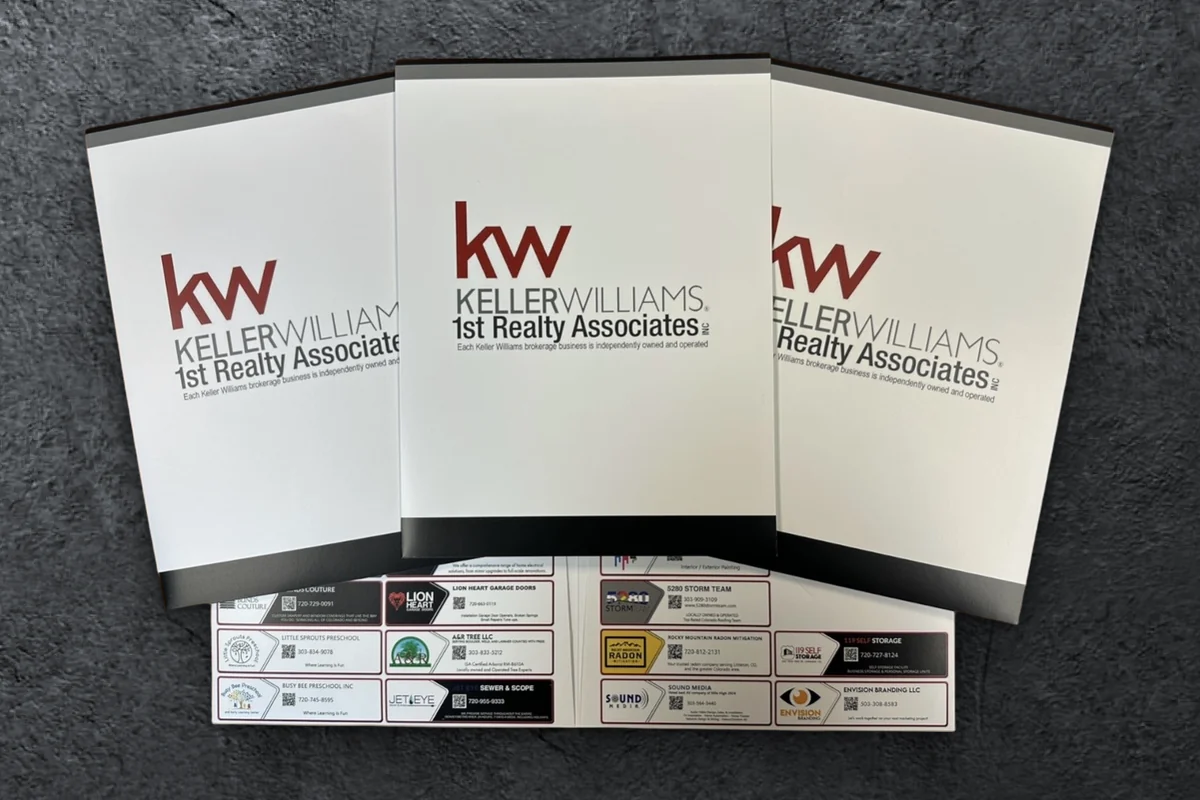 Custom Keller Williams 1st Realty Associates presentation folders, open to show local vendor ads on the pocket