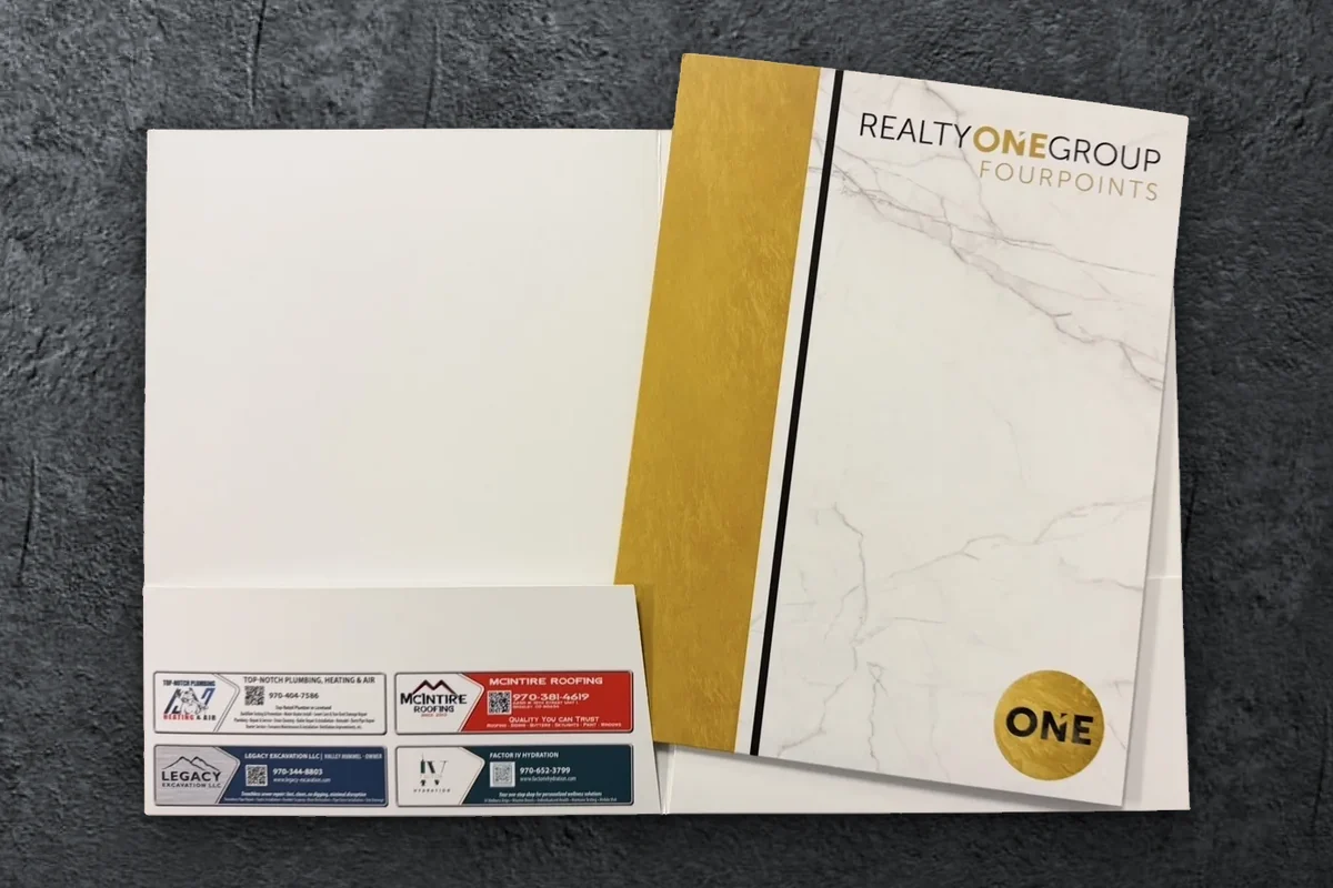 Custom Realty ONE Group Fourpoints presentation folder, open to show local vendor ads printed on the pocket